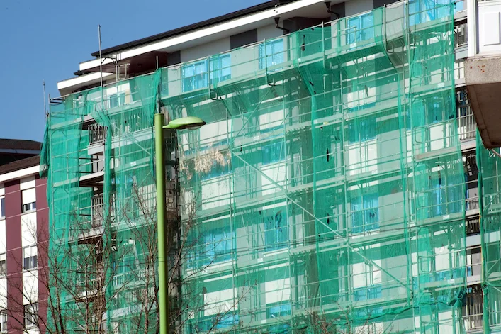 Apartment building covered with scaffolding and safety netting for renovation in Downey CA by Downey Scaffolding Rental