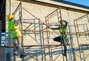 Multi-level scaffolding with wooden planks for construction support by Downey Scaffolding Rental